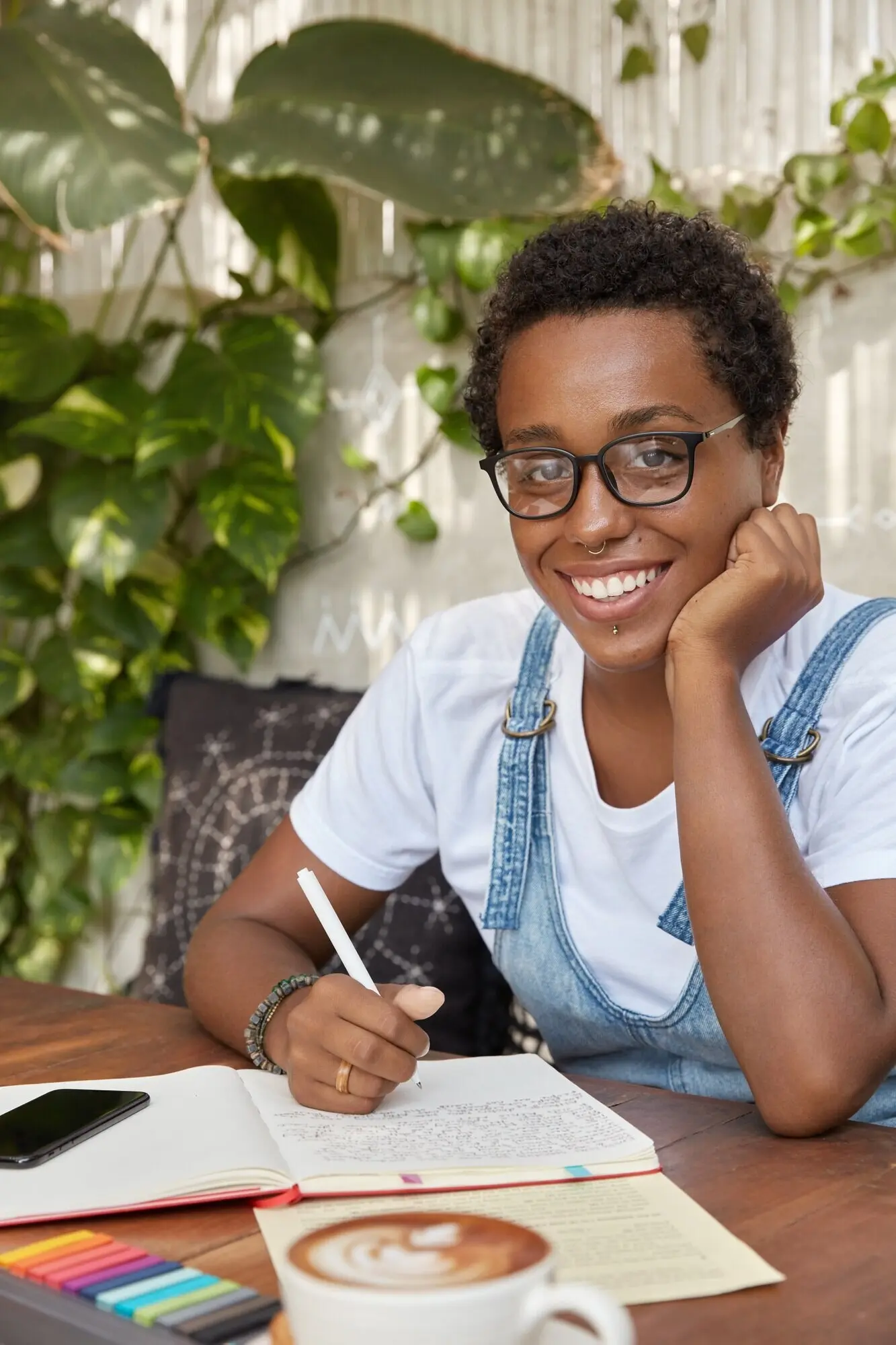 Eine schöne Redakteurin arbeitet an einer Buchrezension und schreibt eine Idee in ein Notizbuch.